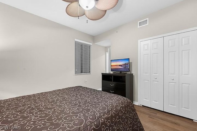 bedroom with ceiling fan, a closet, and wood-type flooring