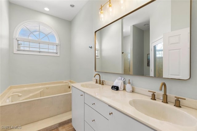 bathroom featuring a washtub and vanity