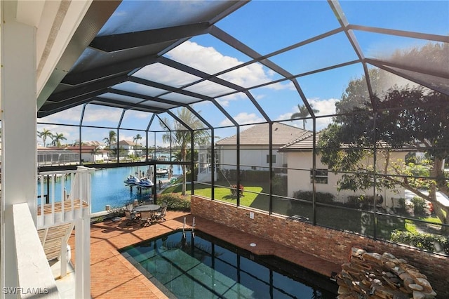 view of patio with a water view and glass enclosure