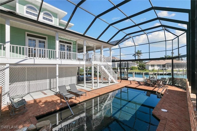 view of pool featuring a lanai, a water view, and a patio