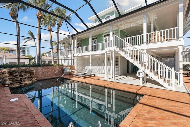 view of swimming pool featuring glass enclosure and a patio