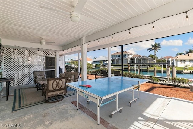 view of patio featuring a water view and ceiling fan