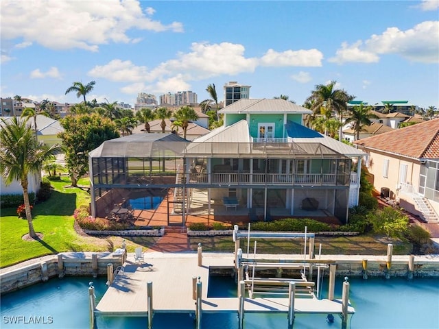 rear view of property with a yard, a lanai, a balcony, a swimming pool, and a water view