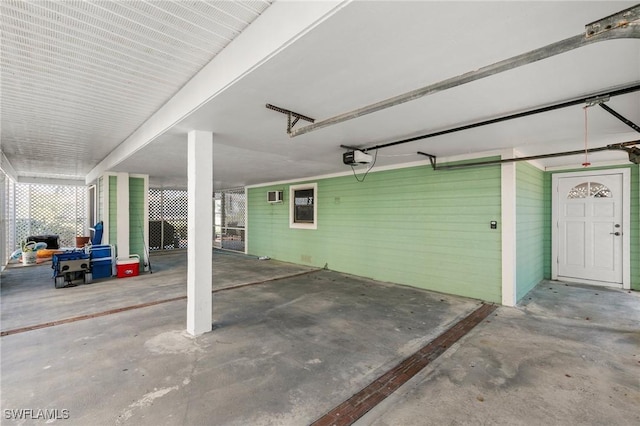 garage featuring an AC wall unit and a garage door opener