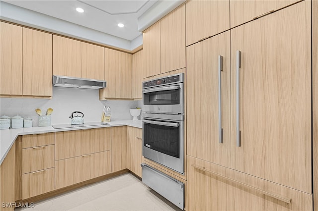 kitchen featuring black electric stovetop, stainless steel double oven, and light brown cabinets