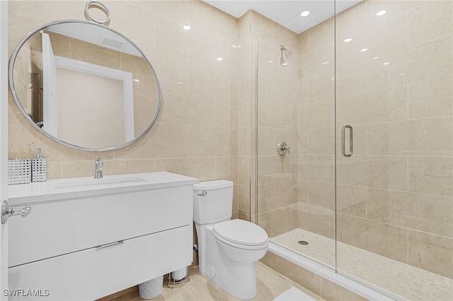 bathroom with walk in shower, vanity, toilet, and tile walls