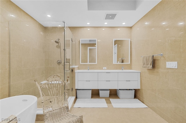 bathroom featuring tile walls, vanity, tile patterned floors, and shower with separate bathtub