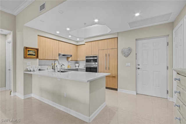 kitchen with light brown cabinetry, sink, a kitchen breakfast bar, kitchen peninsula, and stainless steel double oven