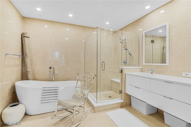 bathroom featuring vanity, separate shower and tub, and tile walls