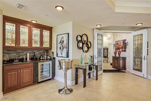 bar with wine cooler, backsplash, dark stone countertops, sink, and light tile patterned flooring