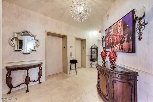 corridor with elevator, a notable chandelier, and light tile patterned flooring