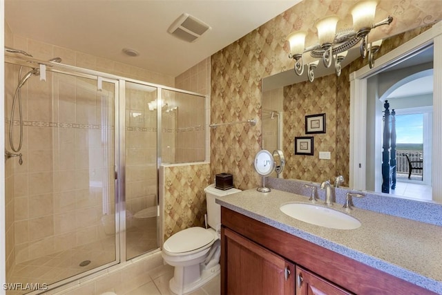 bathroom featuring toilet, vanity, tile patterned flooring, and walk in shower