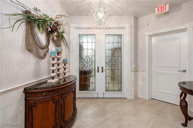 foyer with french doors and a notable chandelier