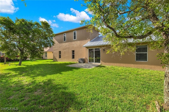 rear view of property with central air condition unit, a yard, and a patio