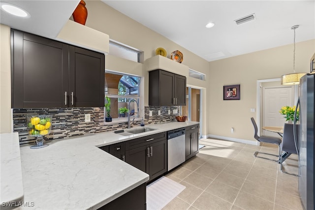 kitchen with sink, backsplash, decorative light fixtures, light tile patterned floors, and appliances with stainless steel finishes