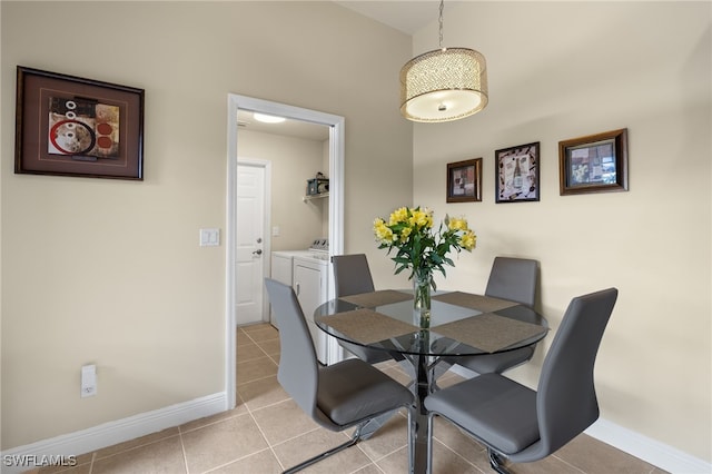 tiled dining room featuring independent washer and dryer