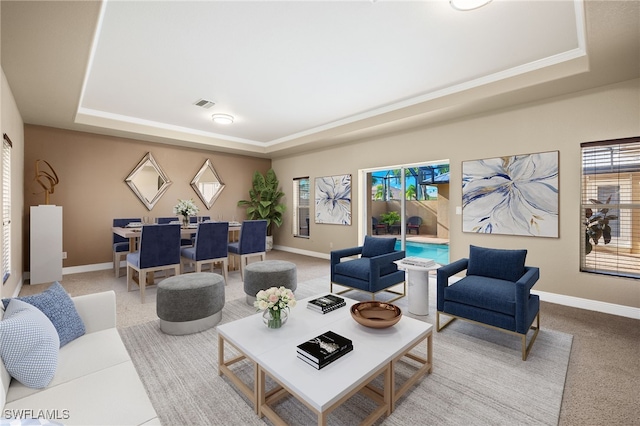 living room with carpet flooring and a tray ceiling