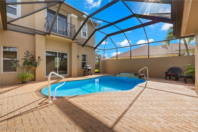 view of pool featuring glass enclosure and a patio