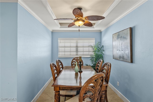 dining area with ornamental molding, a raised ceiling, and light tile patterned floors