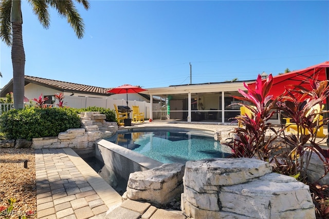 view of swimming pool with a patio and a sunroom