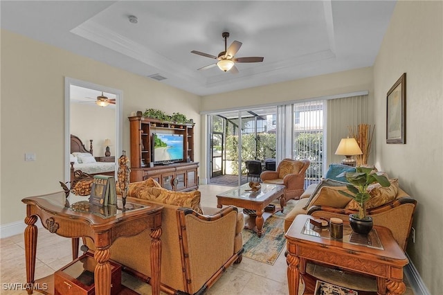 tiled living room featuring a raised ceiling and ceiling fan