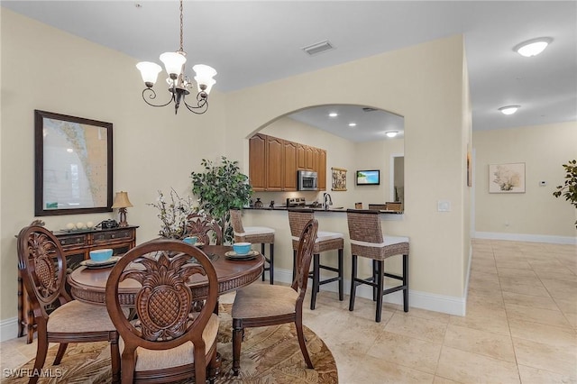 tiled dining area with sink and a chandelier