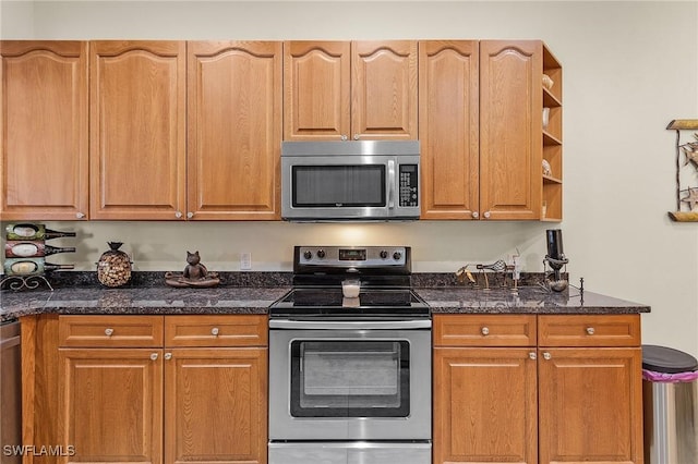 kitchen with appliances with stainless steel finishes and dark stone counters