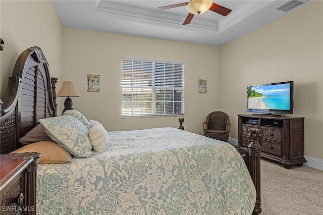 bedroom with a raised ceiling, ceiling fan, light colored carpet, and ornamental molding