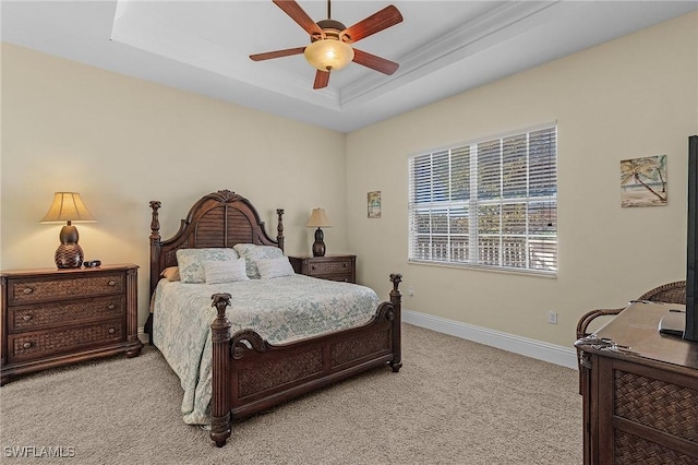 carpeted bedroom featuring a raised ceiling and ceiling fan