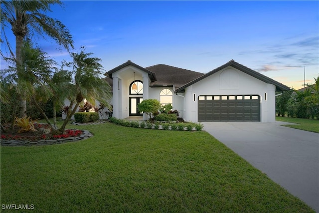 view of front facade featuring a lawn and a garage