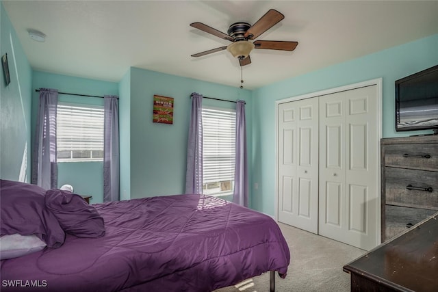 carpeted bedroom with multiple windows, a closet, and ceiling fan