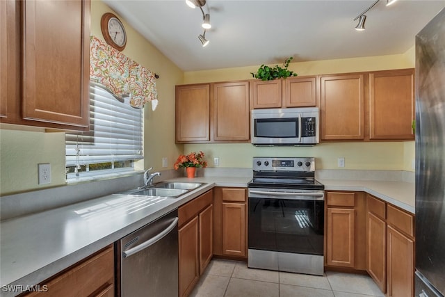 kitchen with sink, light tile patterned flooring, and appliances with stainless steel finishes