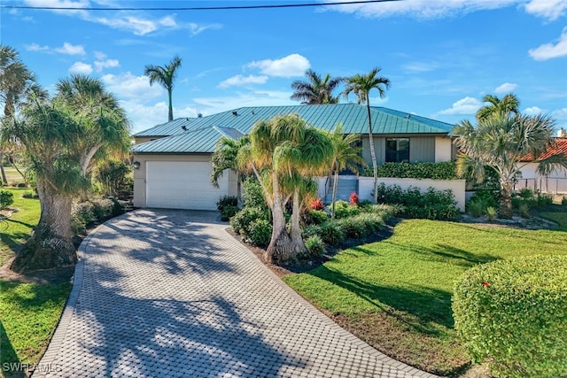 view of front of property with a front yard and a garage