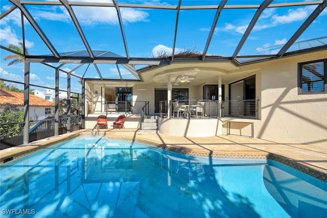 view of swimming pool with a lanai, ceiling fan, and a patio