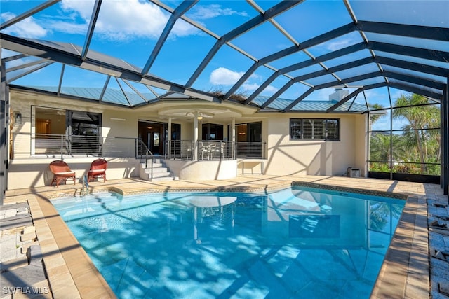 view of swimming pool featuring a lanai, a patio area, and ceiling fan