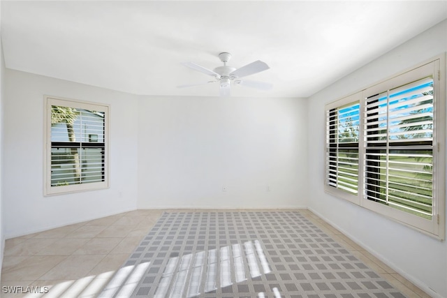 spare room with light tile patterned floors, ceiling fan, and a healthy amount of sunlight