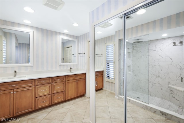 bathroom with tile patterned flooring, vanity, and a tile shower