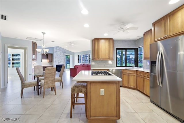 kitchen featuring sink, a kitchen breakfast bar, decorative light fixtures, a kitchen island, and appliances with stainless steel finishes