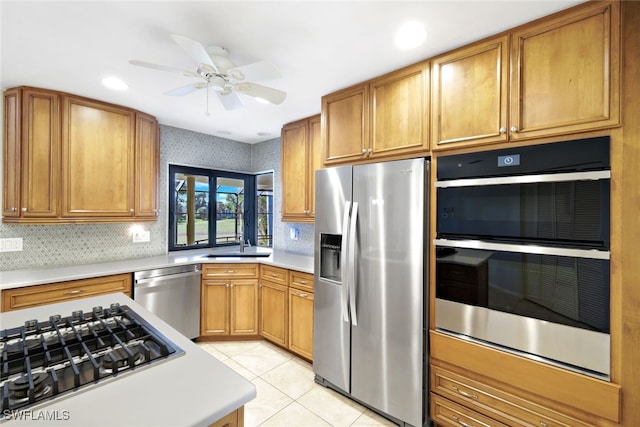 kitchen featuring appliances with stainless steel finishes, tasteful backsplash, light tile patterned floors, and ceiling fan