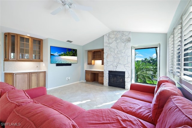 tiled living room with ceiling fan, lofted ceiling, and a fireplace