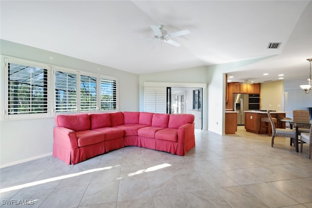 living room featuring light tile patterned floors, ceiling fan with notable chandelier, and vaulted ceiling