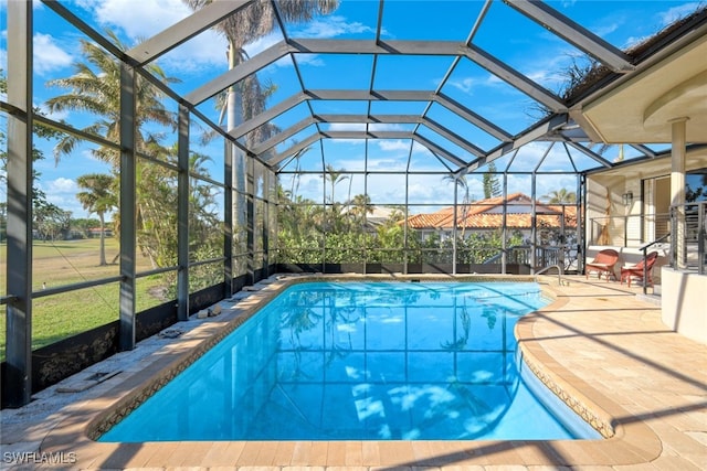 view of swimming pool with glass enclosure and a patio