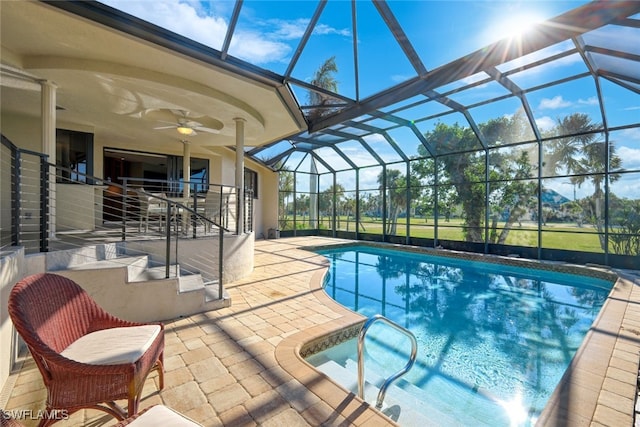 view of pool featuring glass enclosure, ceiling fan, and a patio