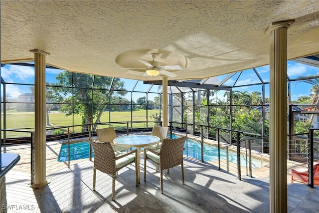 sunroom with ceiling fan, a swimming pool, and a healthy amount of sunlight