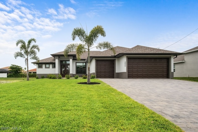 prairie-style home featuring a front yard and a garage