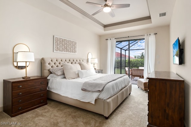 bedroom with ceiling fan, a tray ceiling, light colored carpet, and access to outside