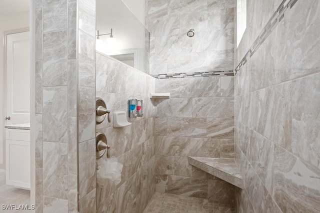 bathroom featuring vanity and tiled shower