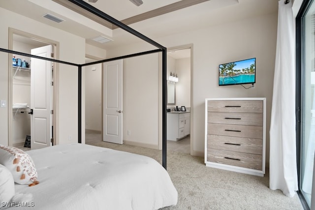 bedroom featuring light carpet and connected bathroom