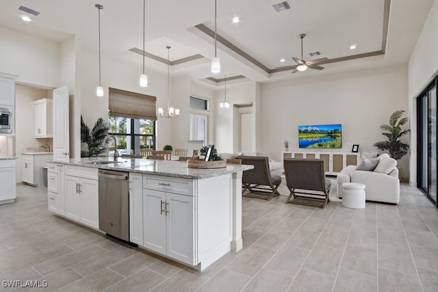 kitchen featuring sink, appliances with stainless steel finishes, an island with sink, white cabinets, and ceiling fan with notable chandelier