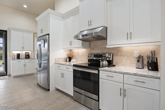 kitchen featuring stainless steel appliances, white cabinetry, light stone counters, and decorative backsplash